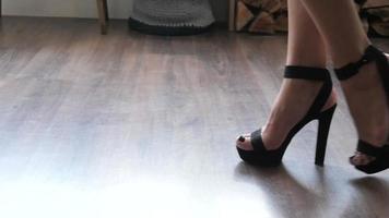 piernas de mujer vienen lentamente en zapatos de tacones altos en una habitación video