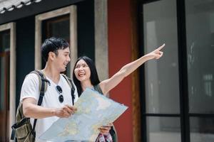 Traveler Asian couple direction on location map in Beijing, China, sweet Asia couple looking on map find landmark while spending holiday trip. Lifestyle couple travel in city concept. photo