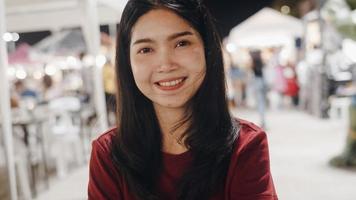 Portrait traveler Asian woman feeling happy smiling looking to camera holiday trip at Bangkok, Thailand, backpacker Asia female enjoy their journey in night at Khao San Road. photo