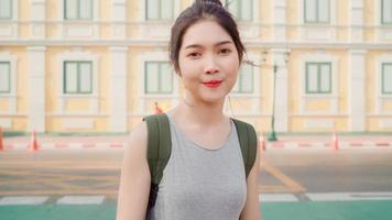 Traveler Asian woman feeling happy smiling to camera holiday trip at Bangkok, Thailand, backpacker Asia female enjoy their journey at amazing landmark in traditional city. Portrait looking at camera. photo