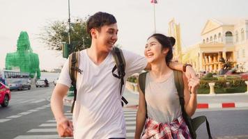 Traveler Asian couple traveling and walking in Bangkok, Thailand, sweet Asia couple feeling happy spending sweet time in holiday trip in sunset. Lifestyle couple travel in city concept. photo