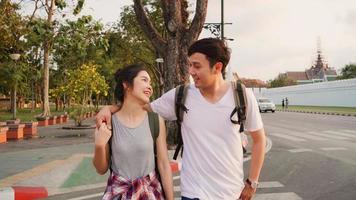 Traveler Asian couple traveling and walking in Bangkok, Thailand, sweet Asia couple feeling happy spending sweet time in holiday trip in sunset. Lifestyle couple travel in city concept. photo