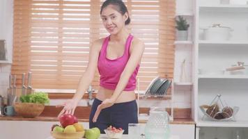 Asian blogger woman make vlog how to diet and lost weight, Young female using camera recording when she eating fruits in the kitchen. Lifestyle influencer women healthy concept. photo