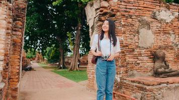 mujer asiática viajera que pasa un viaje de vacaciones en ayutthaya, tailandia, mujer mochilera japonesa disfruta de su viaje en un hito increíble en la ciudad tradicional. concepto de vacaciones de viaje de mujeres de estilo de vida. foto