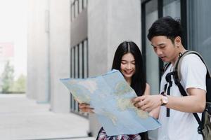 Traveler Asian couple direction on location map in Beijing, China, sweet Asia couple looking on map find landmark while spending holiday trip. Lifestyle couple travel in city concept. photo