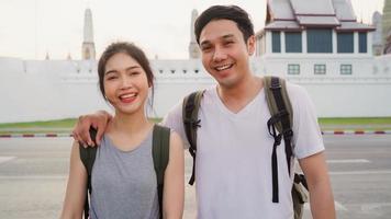 Traveler Asian couple feeling happy smiling to camera holiday trip at Bangkok, Thailand, backpacker Asia couple enjoy their journey at amazing landmark in traditional city. Portrait looking at camera. photo