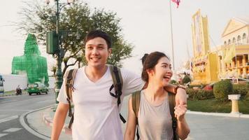 Traveler Asian couple traveling and walking in Bangkok, Thailand, sweet Asia couple feeling happy spending sweet time in holiday trip in sunset. Lifestyle couple travel in city concept. photo