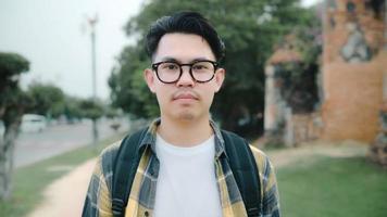 Traveler Asian man feeling happy smiling to camera holiday trip at Ayutthaya, Thailand, backpacker male enjoy his journey at amazing landmark in traditional city. Lifestyle men travel holidays concept photo