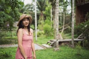 una joven asiática se relaja en el bosque, una hermosa mujer feliz usando el tiempo de relajación en la naturaleza. las mujeres de estilo de vida viajan en concepto de bosque. foto