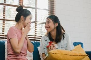 Asian Lesbian lgbtq women couple propose at home, Young Asia lover female happy smiling have romantic time while proposing and marriage surprise wear wedding ring in living room at home concept.