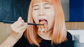 Asian woman eating sushi in japanese restaurant, young female holding chopsticks and eating wagyu beef sushi in lunch time in summer. Lifestyle women eating traditional food concept. photo
