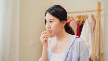Beauty blogger present beauty cosmetics sitting in front camera for recording video. Beautiful asian woman use cosmetics review make up tutorial broadcast live video to social network by internet. photo