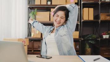 Asian entrepreneur business woman stretching her body after answer customer question, Female owner of SME online relax after working at home. Small business owner at home office concept. photo