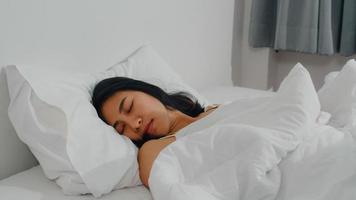 Asian indian lady sleep in room at home. Young Asian girl feeling happy relax rest lying on bed, feel comfortable and calm in bedroom at house at the morning. photo