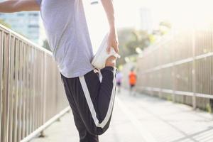 fitness deporte hombres moda ropa deportiva haciendo yoga fitness ejercicio en la calle. Un joven asiático en forma haciendo ejercicio de entrenamiento por la mañana. joven asiático feliz que se extiende en el parque después de hacer ejercicio. foto