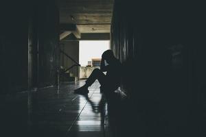 Dramatic, Silhouette of Sad Depressed man sitting head in hands on the floor. Sad man, Cry, drama, lonely and unhappy concept. photo