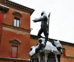 la fuente de neptuno bajo la nieve en invierno. nevadas en bolonia. Italia foto