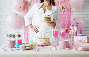 hermosa mujer celebrando la fiesta de cumpleaños sosteniendo un trozo de pastel pidiendo un deseo foto