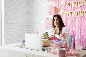 Beautiful woman celebrating birthday using video call chatting with friends photo