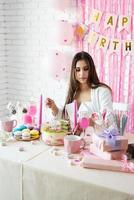 bella mujer celebrando la fiesta de cumpleaños tomando una copa sosteniendo regalos foto