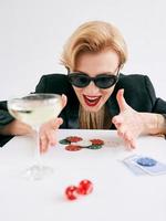 mature stylish woman in black tuxedo and sunglasses happy to win in casino. Gambling, fashion, hobby concept. photo