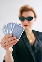 mujer madura y elegante con esmoquin negro y gafas de sol en el casino. juegos de azar, moda, cara de póquer, escalera real, concepto de hobby. foto