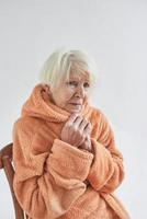 senior ill woman freezing cold at home. Health care, crisis, oldness concept photo