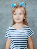 caucasian adorable cute sweet little girl with long blonde hair in striped t-shirt and cat's ears photo