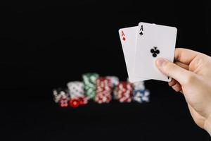human hand holding two aces playing cards photo