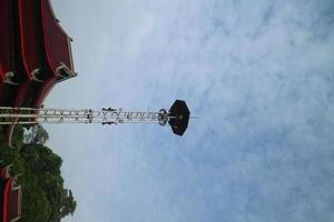 a high lamppost under a bright cloud photo