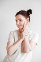 Woman with pigtails and a funny face wearing a T-shirt on a white background. Copy, empty space photo