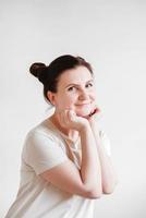 Woman with pigtails and a funny face wearing a T-shirt on a white background. Copy, empty space photo