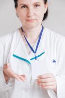 Woman doctor in a white coat holding a empty blank badge photo