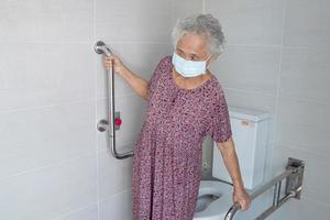 Asia mayor o anciana anciana mujer paciente uso inodoro baño manejar seguridad en enfermería hospital, concepto médico fuerte saludable. foto