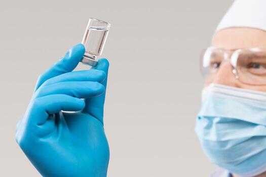 médico sosteniendo una viola con vacuna contra el virus de la corona. foto