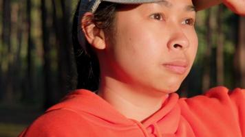 Female runners in a hat prepares for jogging outdoors. video