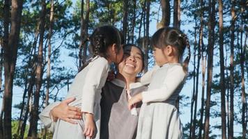Two cute siblings girls having fun with a beautiful young mother in the park. Motherhood and family concept. Children spend time with family on vacation. video