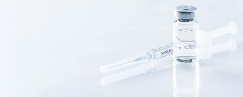 Medical syringe with a needle and a bollte with vaccine. photo