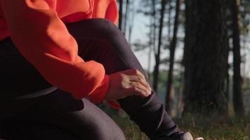 una corridore femminile si massaggia le gambe crampi durante la corsa. atleti infortunati durante l'esercizio. concetto di salute e sport.