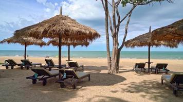guarda-chuva e cadeira de praia com coqueiro e fundo de praia do mar e céu azul - férias e férias video