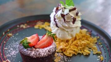 lave de gâteau au chocolat avec glace à la fraise et à la vanille sur plaque noire video