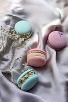 pink and mint french macaroons or macarons cookies and a white flowers on a cloth background. Natural fruit and berry flavors, creamy stuffing for valentines mother day easter with love food