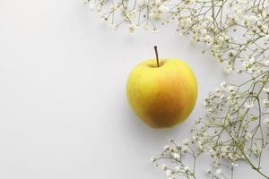 fruta fresca de manzana con flores blancas sobre un fondo blanco. la vista desde arriba. concepto de primavera verano. copie el espacio para el diseño foto