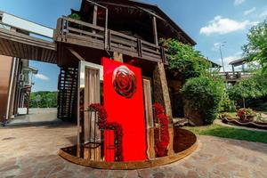 Wedding decor. the wedding ceremony area in the backyard is decorated with red roses flower arrangements photo