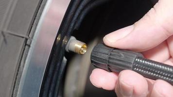 Inflating tire. man hand open valve cap and inflate car tyre before driving. video