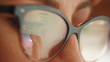 Reflection in glasses of the female hands and credit card making e bank online payment.