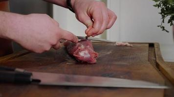 The chef cuts raw meat with the knife. video