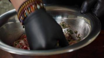 Close-up mixing minced meat with spices in a bowl before cooking.