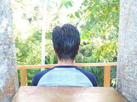 back view of a man's hair against the background of trees photo