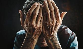 senior man covering his face with his hands.vintage tone photo